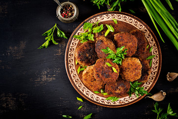 Juicy delicious meat cutlets on a dark table. Russian cuisine. Top view