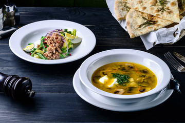 mushroom soup in a cafe, lunch menu on a dark table