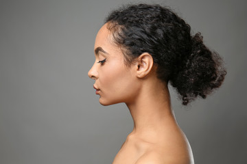 Fototapeta na wymiar Portrait of beautiful African-American woman on grey background