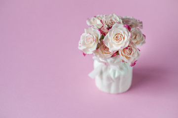Coral roses in vase on pink background. Greeting card. Happy Mother's Day, Women's Day or Birthday. Minimalism, selective focus, place for text.
