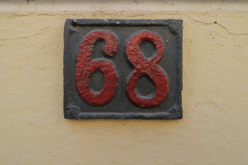 Vintage grunge square metal rusty plate of number of street address with number. Close up, brand.
