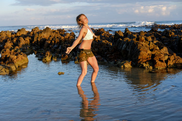 A gorgeous yoga instructor dancing by the beach in water