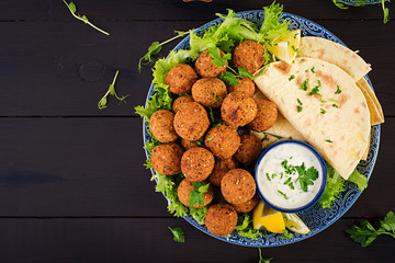 Falafel, hummus and pita. Middle eastern or arabic dishes on a dark background. Halal food. Top view. Copy space
