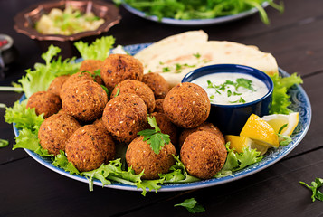 Falafel, hummus and pita. Middle eastern or arabic dishes on a dark background. Halal food.