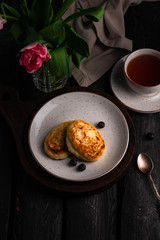 pancakes on a brown backdrop, cup of tea, tulips on background