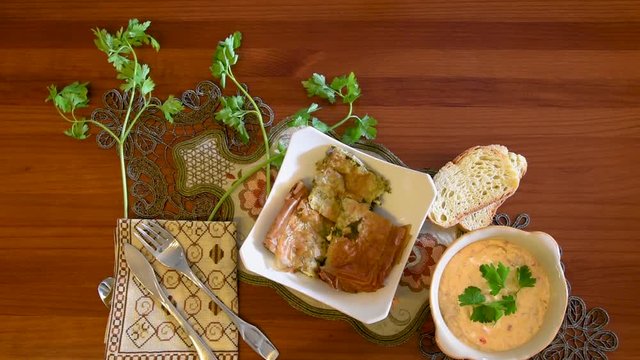 Healthy mediterranean cuisine, three dishes concept for lunch or dinner. Closeup of taking the letuce salad and the tomato from the table