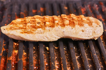 Grilled cooking. Grilled chicken breast lies on the grill.
