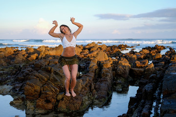 Flexible yoga instructor stretching on the beach