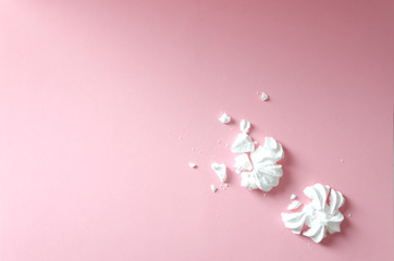 Crumbled meringue on the pink background, top view. Empty space for your design