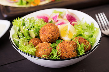 Falafel and fresh vegetables. Buddha bowl. Middle eastern or arabic dishes on a dark background. Halal food.