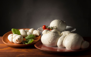 still life with mozzarella cheese ,olive oil ,tomato and basil on the wooden table