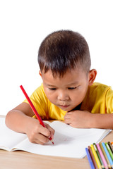 Cute cheerful child drawing using color pencil while sitting at table isolated on white background