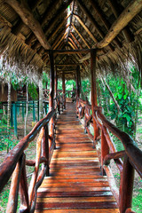 An elaborate wood railing on an elevated wood walkway as part of a remote jungle resort in southern Belize.