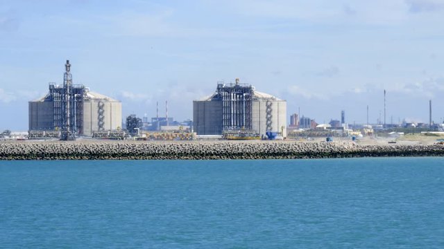 LNG storage tanks in Liquefied Natural Gas Terminal, with an oil refinery in background,  Dunkerque, France
