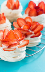 Beautiful pavlova cakes with strawberries on a blue background. Selective focus. Tasty sweet breackfast. Wedding morning. Meringue with cream.