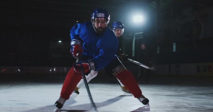 Two man playing hockey on ice rink. hockey Two hockey players fighting for puck. STEADICAM SHOT