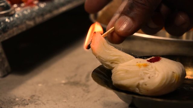Closeup of hands lighting the Aarti deepa(The Hindu Ceremony of Light) in the temple during a festival.