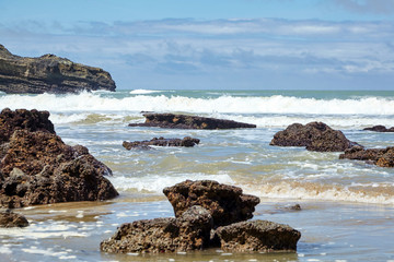 Obraz premium Sharp stones protruding from the water at low tide. Atlantic ocean coast
