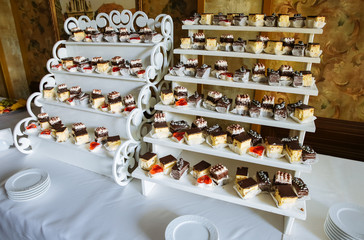 Delicious candy bar at the wedding reception. Chocolate cakes and muffins.Sweet red hearts. Desserts for guests.