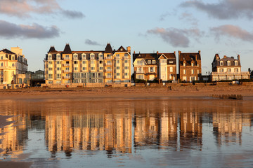 Obraz premium Beach in the evening sun and buildings along the seafront promenade in Saint Malo. Brittany, France