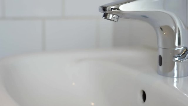 Man getting a glass of water from a touchless faucet