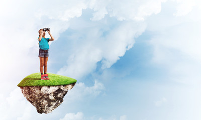 Concept of careless happy childhood with girl looking in binoculars