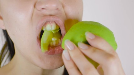 A young girl eats a green apple. Healthy food, vegetarianism