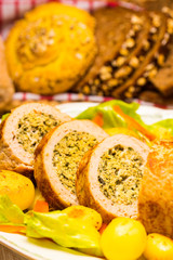 Meatloaf with spinach stuffing served with fried potatoes and carrot.