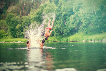 Men jumping into the water with splashing