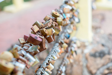Fototapeta na wymiar Lock for couple make a promise to love forever, master keys hanging on the rails of bridge, the sign of love and romantic affection as a landmark. Symbolic love locks hang along.