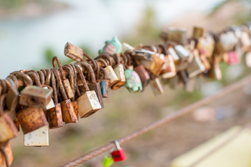 Lock for couple make a promise to love forever, master keys hanging on the rails of bridge, the sign of love and romantic affection as a landmark. Symbolic love locks hang along.