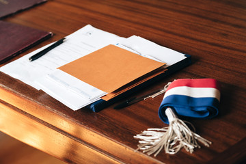 Documents placed on the table of a town hall, with a mayor's scarf and a soft light atmosphere