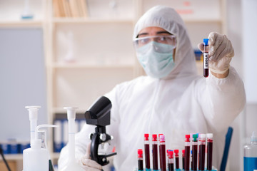 Young handsome chemist working in the lab