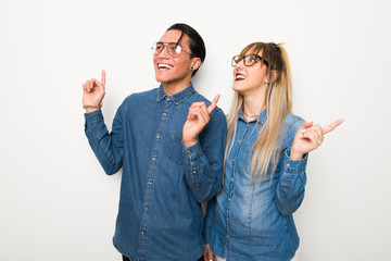 Young couple with glasses pointing with the index finger a great idea