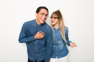 Fototapeta premium Young couple with glasses smiling a lot while putting hands on chest