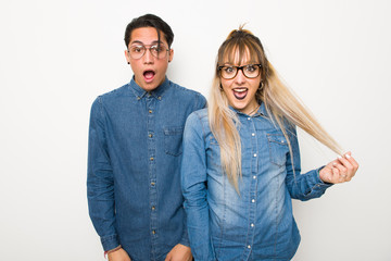 Young couple with glasses with surprise and shocked facial expression