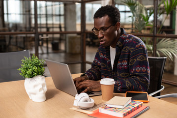 Concentrated young man doing office work in the workplace