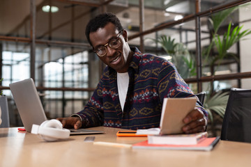 Man taking notes while working with a computer