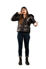 Full-length shot of Woman with glasses making phone gesture and doubting