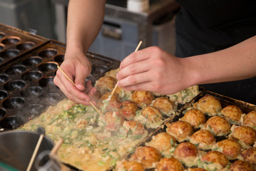 cooking Takoyakis at a street stand in Osaka, Dotonbori