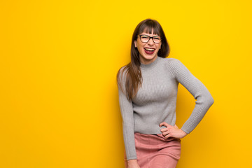 Obraz premium Woman with glasses over yellow wall happy and smiling