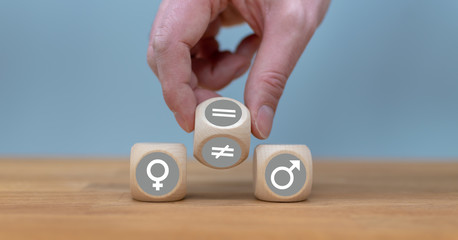 Symbol for gender equality. Hand turns a dice and changes a unequal sign to a equal sign between...