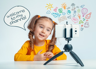 beautiful cute little blogger girl recording a video with smartphone media icons flying