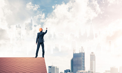 Man architect draw silhouette of modern city on blue sky. Mixed 