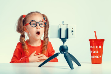 beautiful cute little blogger girl recording a video with smartphone