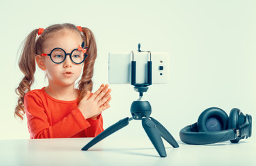 beautiful cute little blogger girl recording a video with smartphone