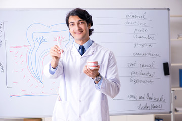 Young handsome dentist in front of the whiteboard