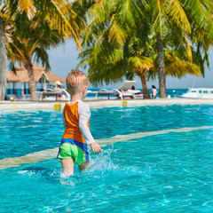 Naklejka premium Toddler boy in resort swimming pool