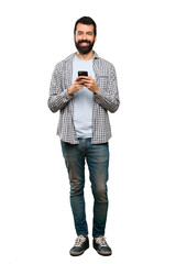 Handsome man with beard sending a message with the mobile over isolated white background