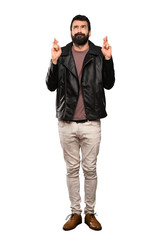 Handsome man with beard with fingers crossing and wishing the best over isolated white background